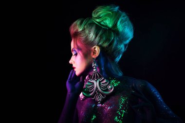 Parlak sanat-makyaj, mor tonlarda genç çekici sarışın kız. Rhinestones ve glitter vücut boyama.