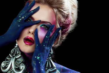 Glamour güzellik şoka girmiş. Genç çekici sarışın kız olarak parlak sanat-makyaj, Birleşmiş bir baş eller.