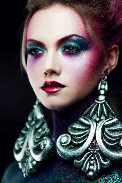 Joven chica rubia atractiva en brillante arte-maquillaje, pelo alto, pintura corporal. Diamantes de imitación y purpurina —  Fotos de Stock