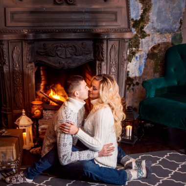 Erkek ve bir kadın tarafından şömine başında sıcak örme kazak