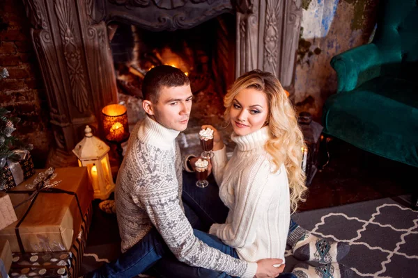 Muž a žena v teplých pletených svetříků u krbu — Stock fotografie