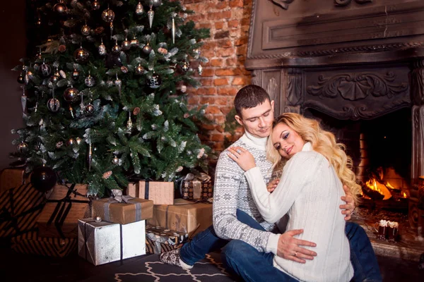 Joyeux Noël. Jeune couple célébrant le Nouvel An à la maison. Homme et femme près de la cheminée — Photo