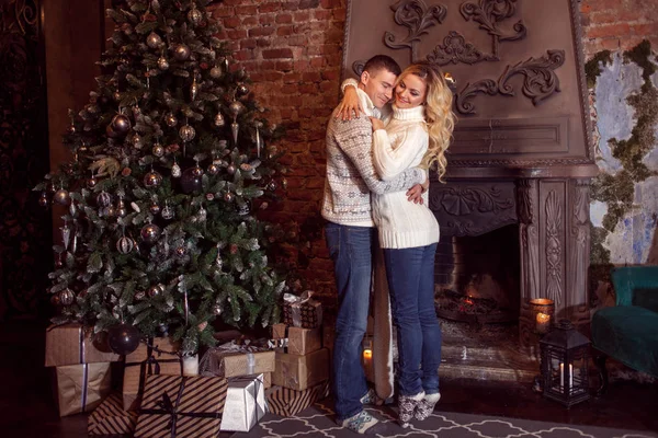 God Jul. Unga par firar nyår hemma. Man och kvinna som kramas — Stockfoto