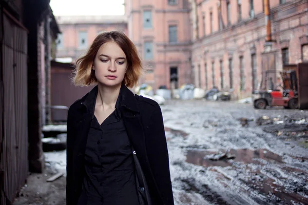 Ragazza dai capelli rossi triste sullo sfondo del paesaggio industriale. Donna che cammina — Foto Stock