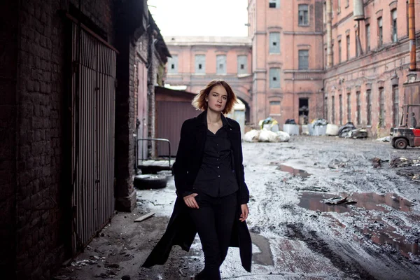 Θλιβερή κοκκινομάλλα κοπέλα για το ιστορικό βιομηχανικό τοπίο. Γυναίκα που περπατά — Φωτογραφία Αρχείου