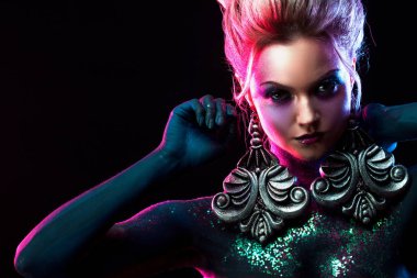 Parlak sanat-makyaj, mor tonlarda genç çekici sarışın kız. Rhinestones ve glitter vücut boyama.