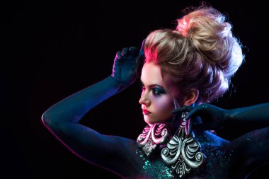 Parlak sanat-makyaj, mor tonlarda genç çekici sarışın kız. Rhinestones ve glitter vücut boyama.