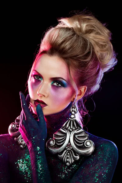 Aantrekkelijke blonde meisje in heldere kunst-make-up, in paarse tinten. Steentjes en glitter lichaam schilderij. — Stockfoto