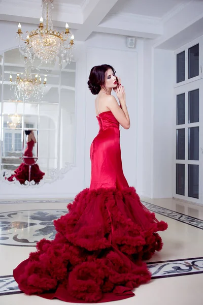 Belleza Morena modelo mujer en vestido rojo noche. Maquillaje y peinado de lujo de moda hermosa, longitud completa —  Fotos de Stock