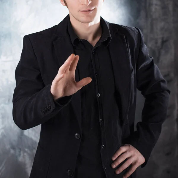 Say no. Young man conducts a dialogue in black suit on textured grey background — Stock Photo, Image