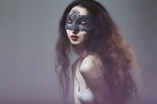 Милая молодая девушка с длинными волосами в маскарадной маске — стоковое фото