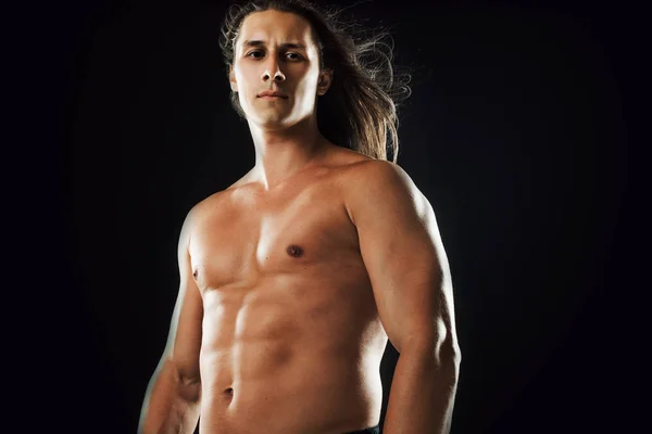 Jovem atraente do sexo masculino, tipo de corpo atlético, cabelos longos, rosto pensativo — Fotografia de Stock