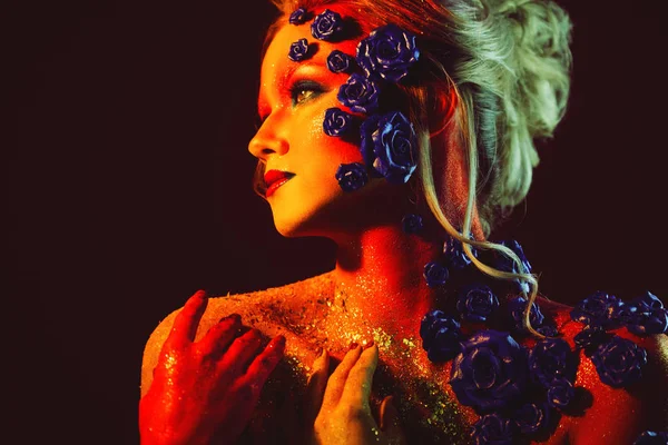 Portrait de jeune femme séduisante avec un maquillage d'art. Couleurs vives, paillettes sur le visage et décoration florale — Photo