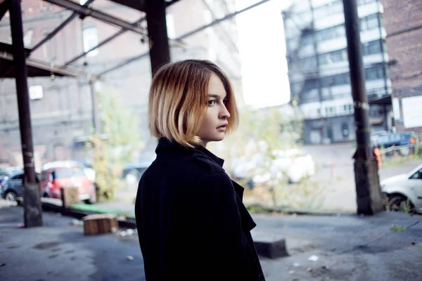 Ragazza dai capelli rossi triste sullo sfondo del paesaggio industriale. Donna che cammina — Foto Stock