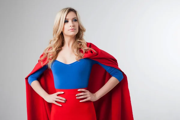 Žena superhrdina. Mladá a krásná blondýnka v obrazu superheroine v červené Cape pěstování — Stock fotografie