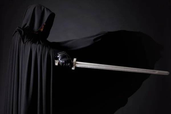 Portret odważny wojownik Wędrowca w czarnym płaszczu i mieczem w dłoni. — Zdjęcie stockowe