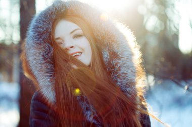 Genç ve çekici kadın yürüyüş, kış, sıcak palto bir kukuleta ile