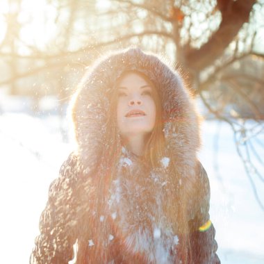 Genç ve çekici kadın yürüyüş, kış, sıcak palto bir kukuleta ile