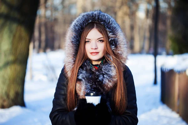 Mulher jovem e atraente em passeio, inverno, casaco quente com capuz, café para ir — Fotografia de Stock