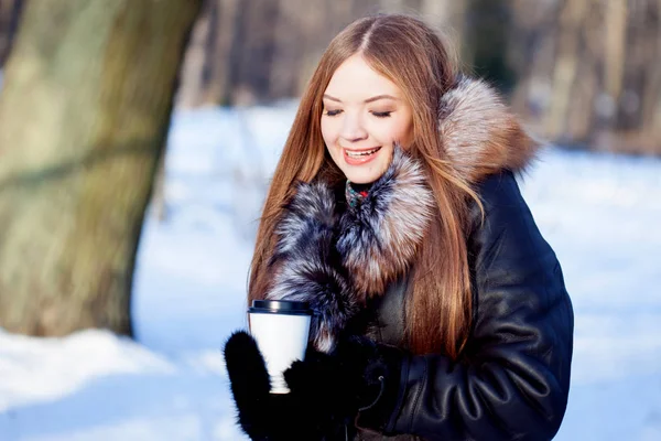 若くて魅力的な女性は徒歩、冬、暖かいコート フード、コーヒーを飲みに — ストック写真