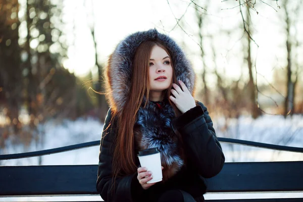 Mulher jovem e atraente em passeio, inverno, casaco quente com capuz, café para ir — Fotografia de Stock