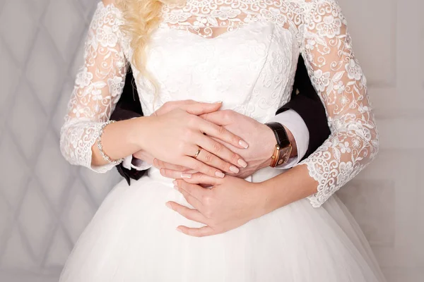 Жених обнимает невесту сзади. Свадебное платье. Руки крупным планом . — стоковое фото