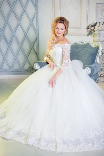 Portrait de charmante femme en robe de mariée. La jeune mariée s'assoit sur une chaise — Photo