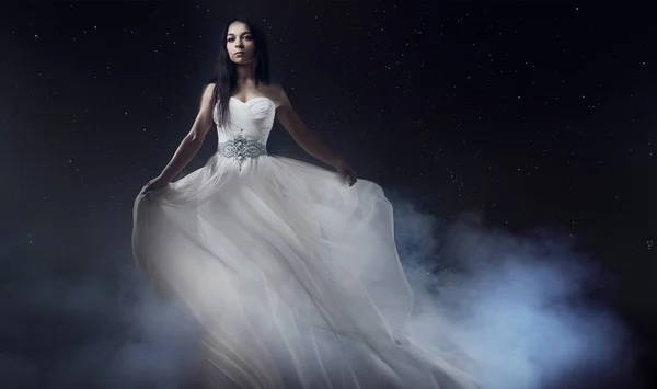 Beautiful sexy young woman. Portrait of girl in long white dress, mystical, mysterious style, background of the starry sky Royalty Free Stock Images