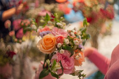 Atölye çiçekçi, buketler ve çiçek düzenlemeleri yapma. Bir buket gül toplama kadın. Yumuşak odak