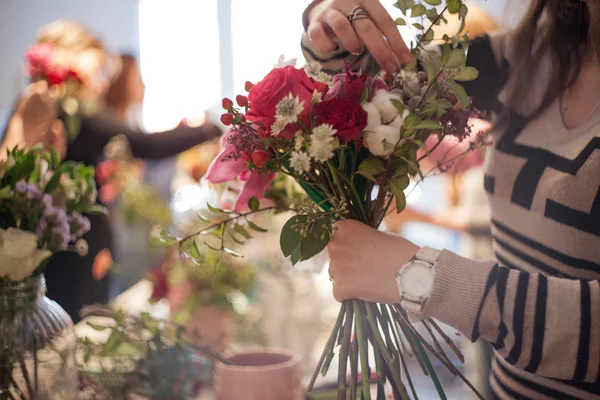 Workshop florist, making bouquets and flower arrangements. Woman collecting a bouquet. Soft focus