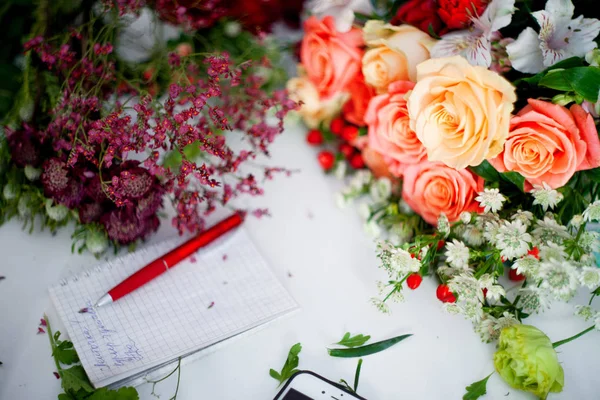 Taller floristería, mesa con flores, naturaleza muerta. Enfoque suave — Foto de Stock