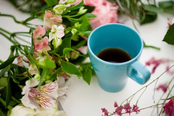 Kopp te på bordet, koppla av. Workshop florist, bord med blommor, stilleben. Mjukt fokus — Stockfoto