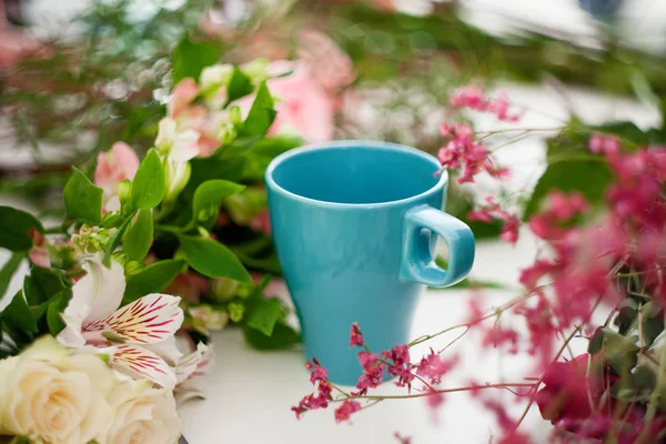 Tasse Tee auf dem Tisch, entspannen. Florist, Tisch mit Blumen, Stillleben. Weicher Fokus — Stockfoto