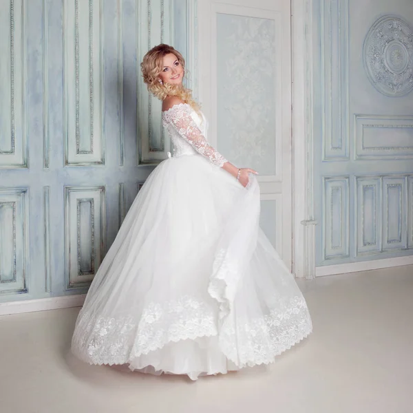 Retrato de mujer encantadora en vestido de novia. Bailando en las paredes de fondo con molduras clásicas — Foto de Stock