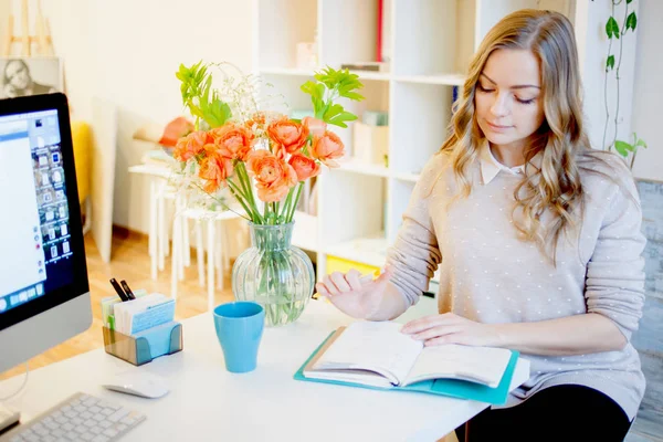 Νεαρός επιχειρηματίας κάθεται στο γραφείο και την εργασία. Όμορφη γυναίκα γεμίσματα planner — Φωτογραφία Αρχείου
