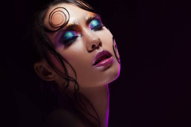 Genç güzel kız parlak makyaj ile ıslak göz Parlatıcı, koyu arka plan