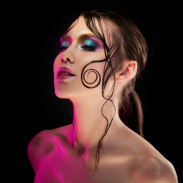 Krásná mladá dívka světlé make-up s Mokrá trička lesk, tmavé pozadí — Stock fotografie