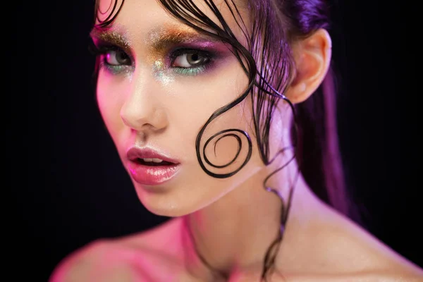 Jovem menina bonita maquiagem brilhante com um olhar molhado brilho, fundo escuro — Fotografia de Stock