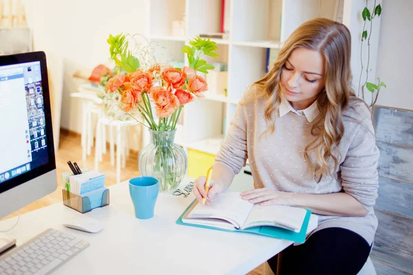 Junge Geschäftsfrau, die am Schreibtisch sitzt und arbeitet. schöne Frau füllt Planer — Stockfoto