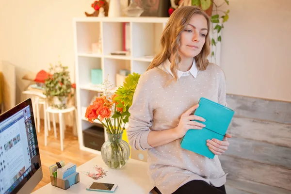 Jeune femme d'affaires assise au bureau et travaillant. Belle femme remplit planificateur — Photo