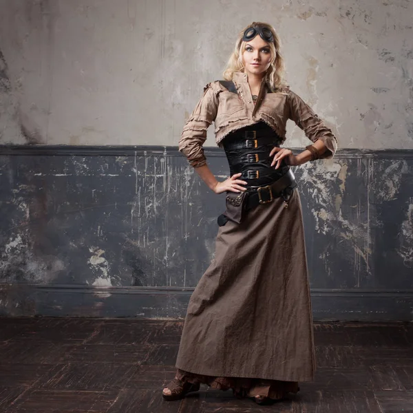 Portrait of a beautiful steampunk woman in Aviator glasses over grunge background. — Stock Photo, Image