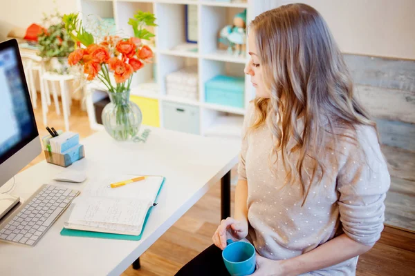 Ung affärskvinna sitter vid skrivbord och arbeta. Vacker kvinna dricker kaffe. Börja dagen — Stockfoto
