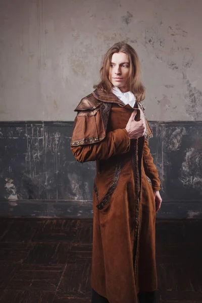 Handsome male in brown cloak, Steam punk style. Retro man portrait over grunge background. — Stock Photo, Image