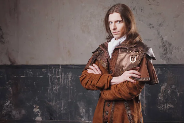 Gutaussehender Mann in braunem Mantel, Steampunk-Stil. Retro-Männerporträt über Grunge-Hintergrund. — Stockfoto