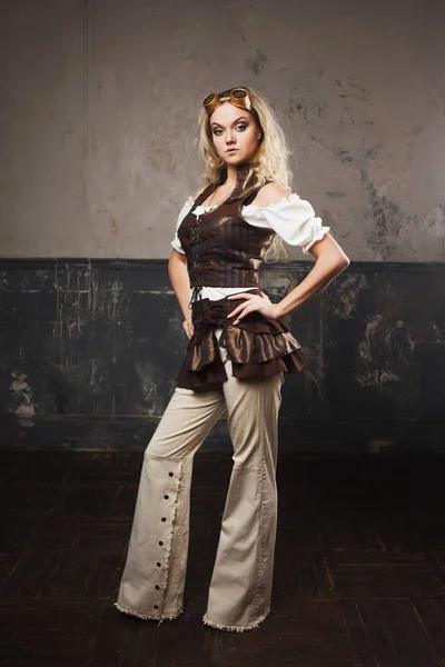 Portrait of a beautiful steampunk woman in Aviator glasses over grey background. Looking up — Stock Photo, Image