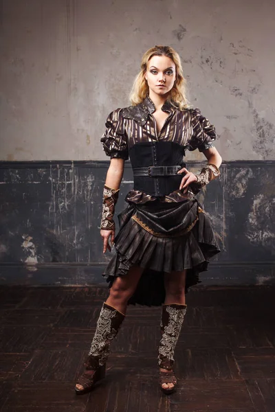 Portrait of a beautiful steampunk woman in the lush striped blouse, over grunge background. — Stock Photo, Image