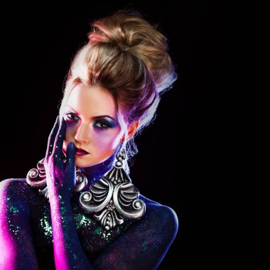 Parlak sanat-makyaj, yüksek saç, vücut boyama genç çekici sarışın kız. Yüzünde palmiye