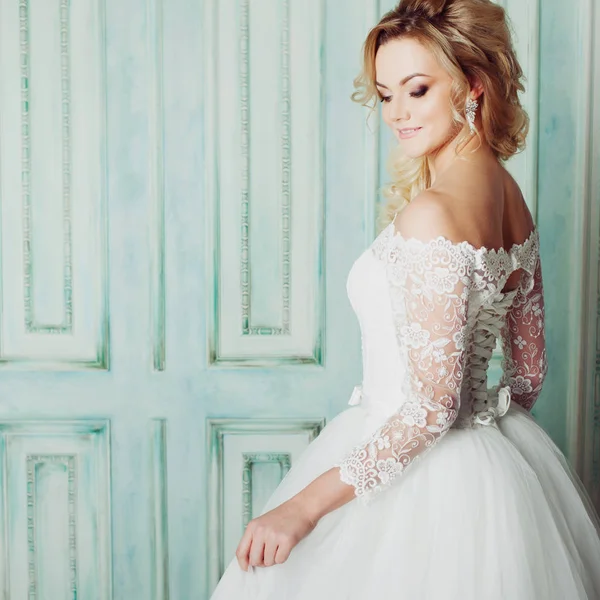 Retrato de mujer encantadora en vestido de novia. Bailando en las paredes de fondo con molduras clásicas — Foto de Stock