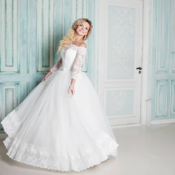 Retrato de mujer encantadora en vestido de novia. Bailando en las paredes de fondo con molduras clásicas — Foto de Stock