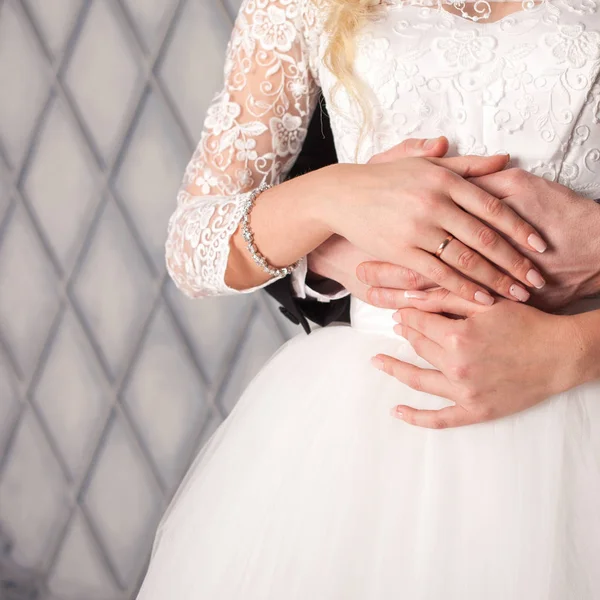 Brudgummen omfamnande brud bakifrån. Brudklänning. Händer närbild. — Stockfoto